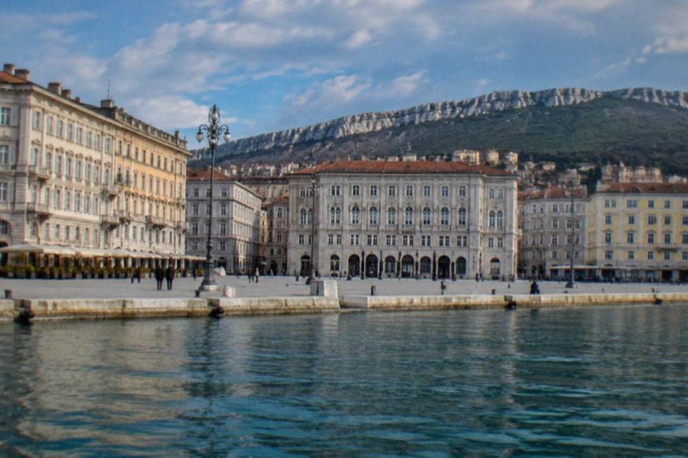 The wide open seafront square of Trieste seen from the water side with the historic buildings in a row