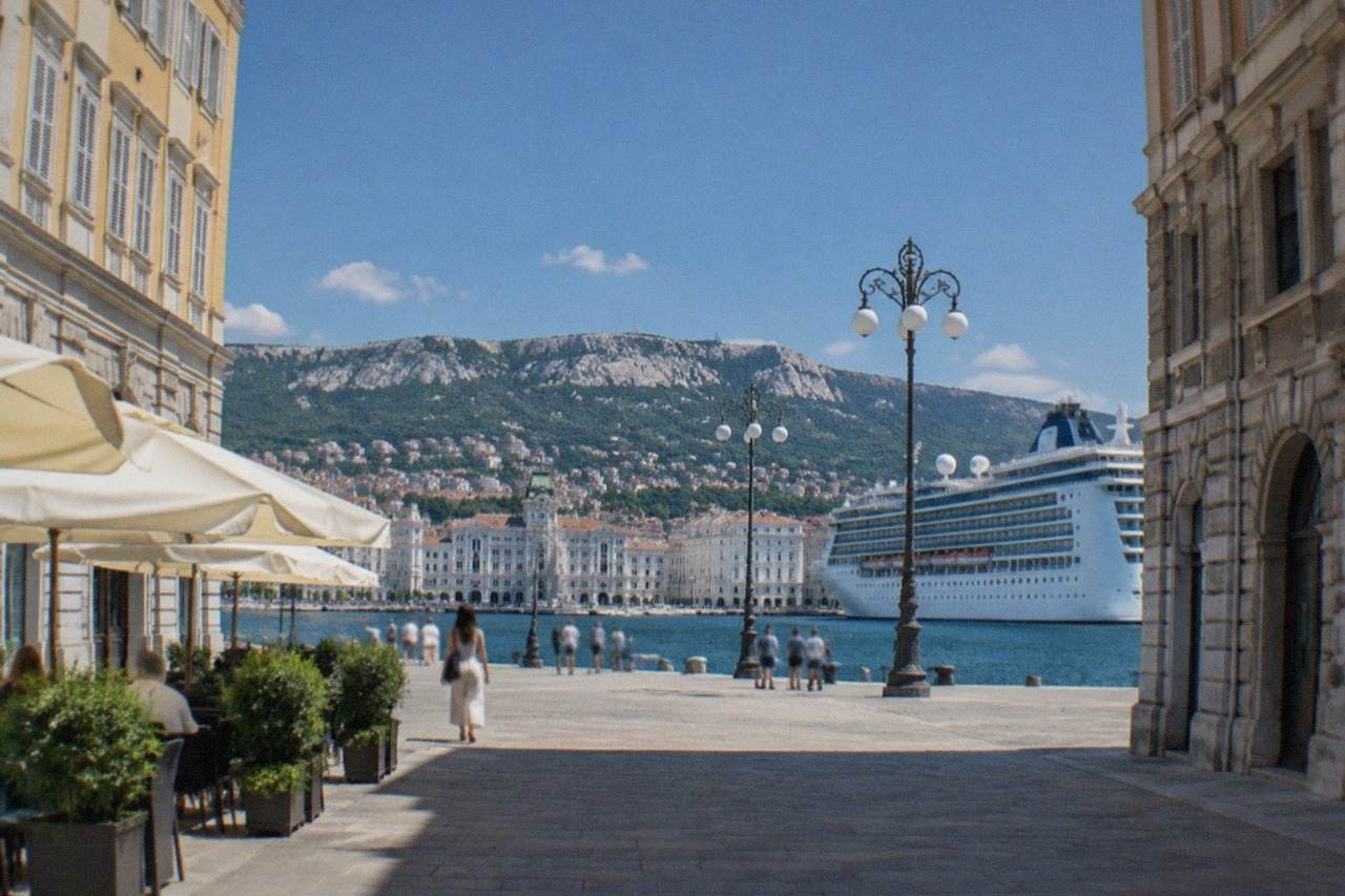 A cruise ship tied up along the Trieste waterfront with the city's seafront piazzas behind it
