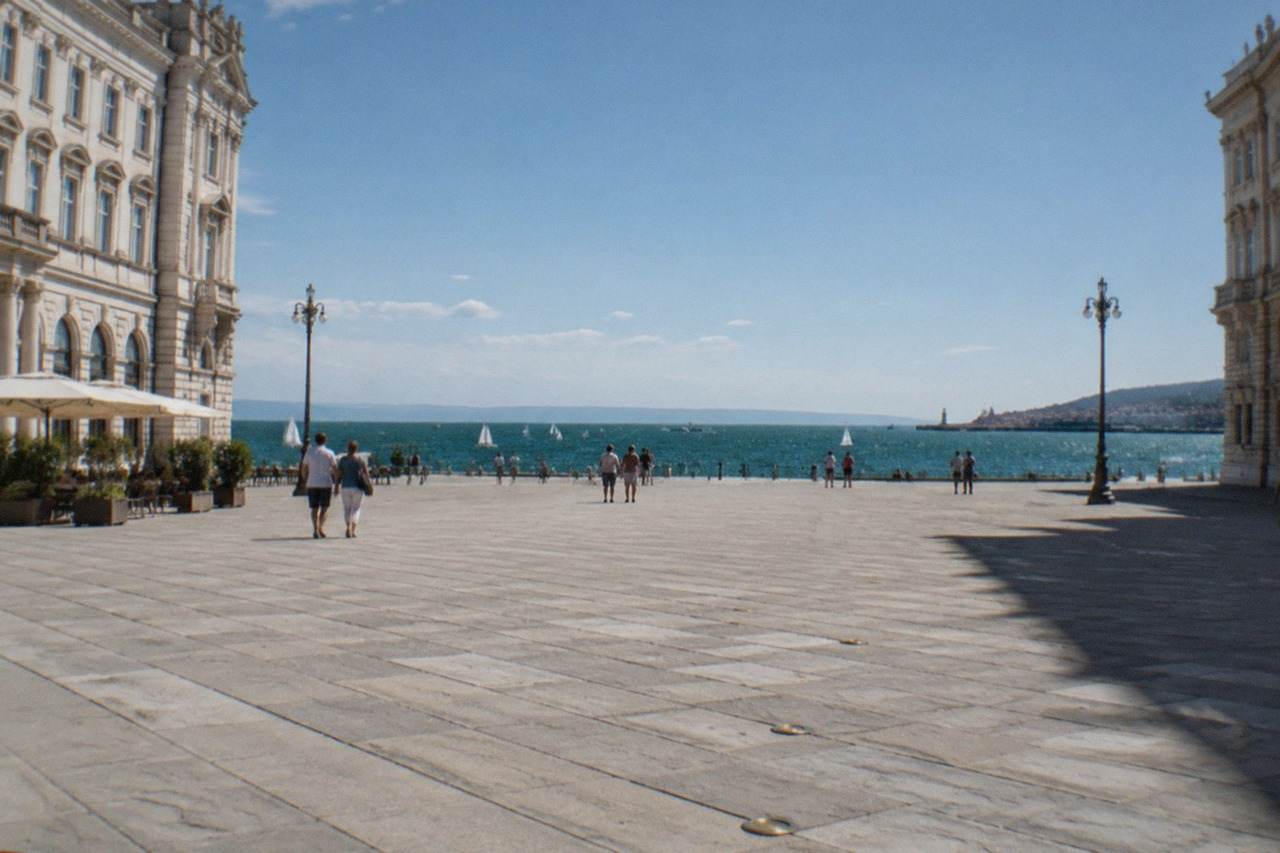 The seafront of Trieste, Italy, with Piazza Unità d'Italia opening onto the water and small boats in the gulf