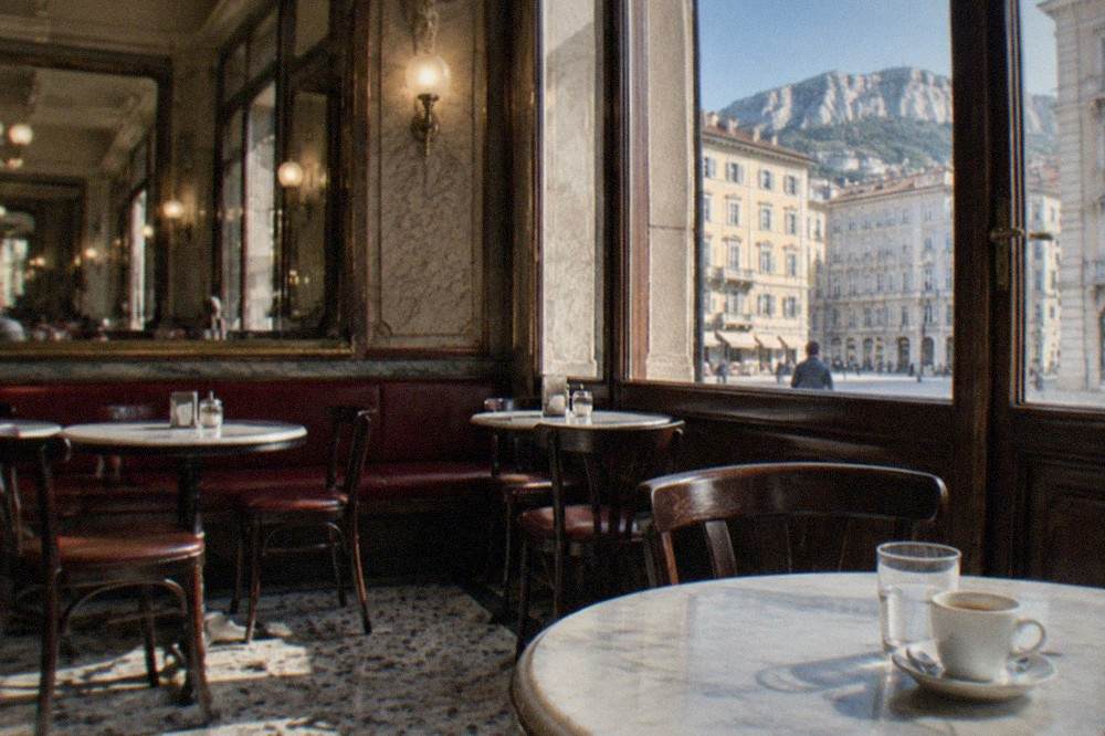 A historic coffee house interior in Trieste with marble tables and mirrored walls