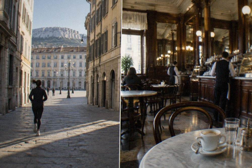 A historic Italian coffee house interior in Trieste with marble tables, mirrors and waiters serving at the counter