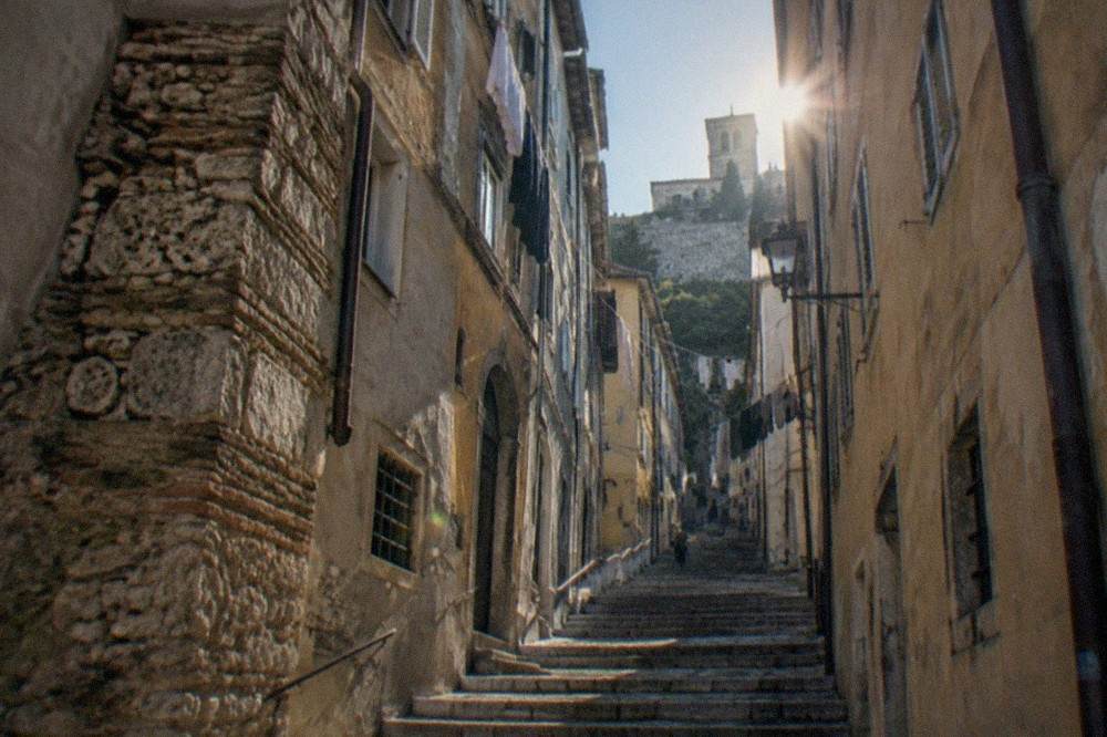 A narrow street in the Città Vecchia old town of Trieste, Italy, rising toward the hill of San Giusto