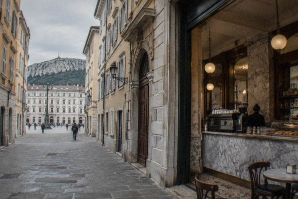 A historic cafe interior in Trieste with marble counters and a coffee counter scene