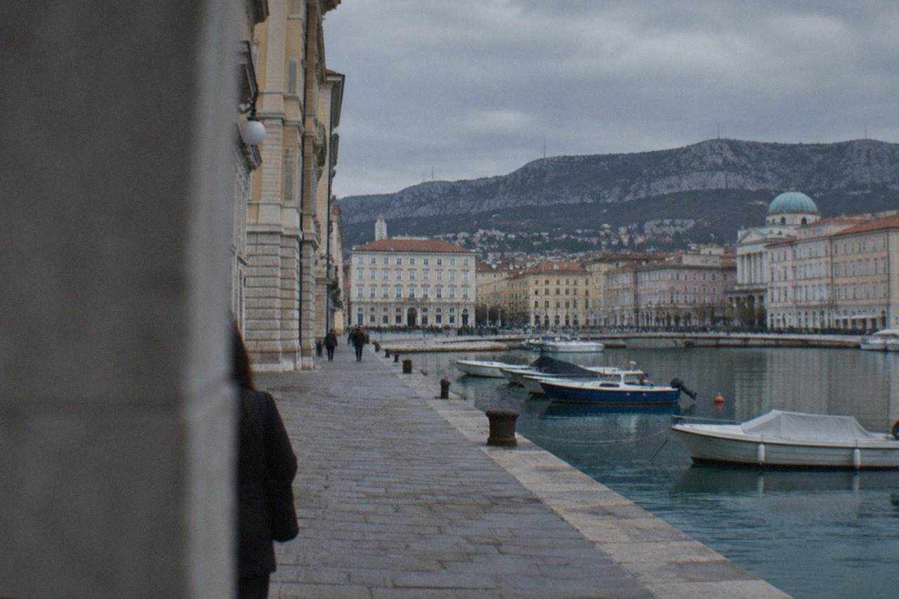Pastel buildings and small boats along the waterfront of a coastal town on the Adriatic Sea
