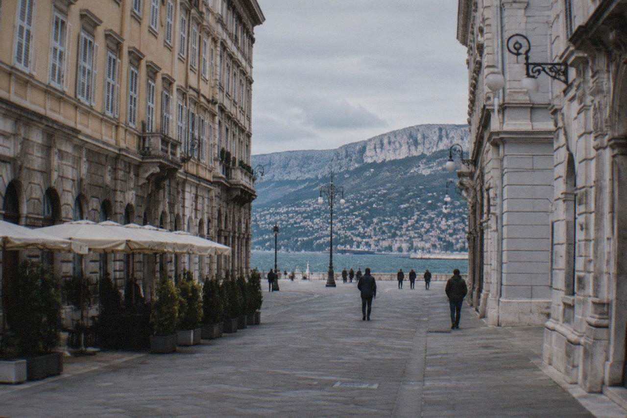Elegant Habsburg-era buildings along a wide Trieste street near the sea