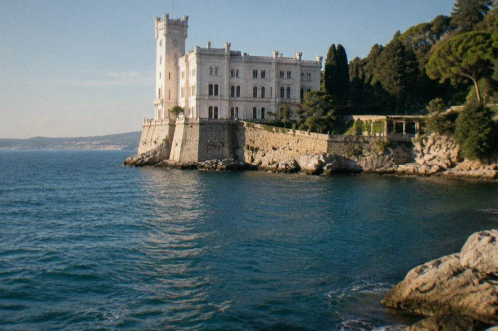 The white facade of Miramare Castle above the sea on the Trieste coastline