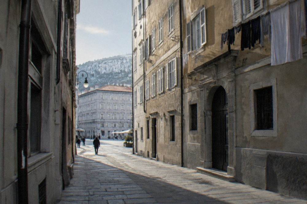 Narrow lane in the old town of Trieste with historic facades and laundry above