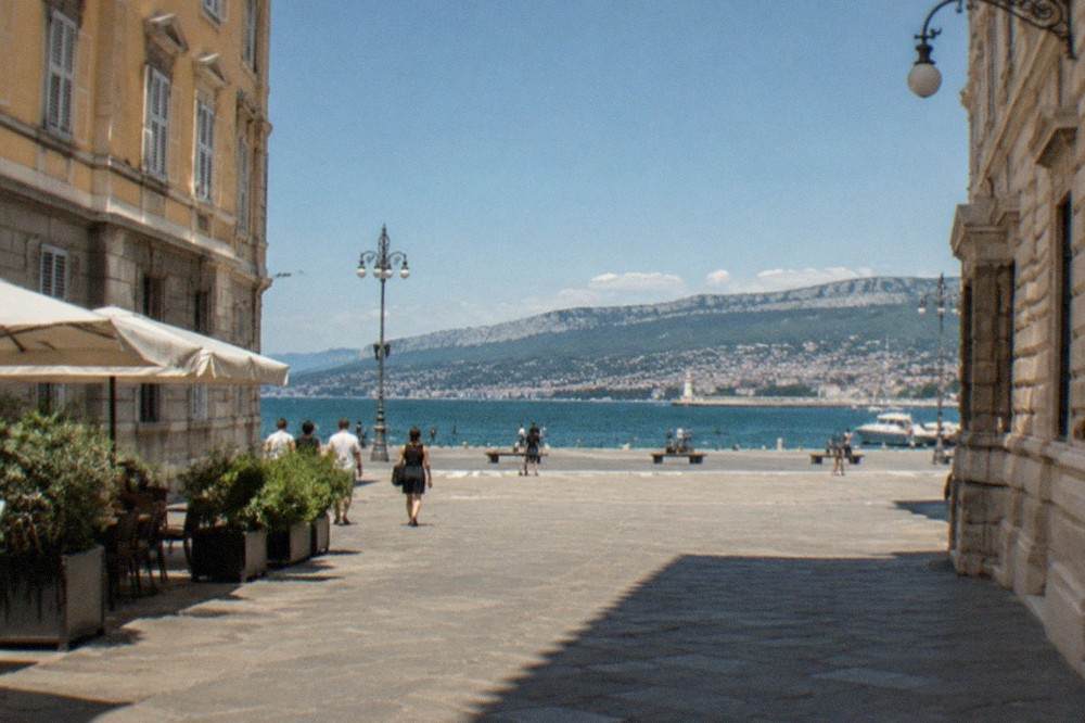 The sea-facing square of Trieste with the gulf and distant hills behind it