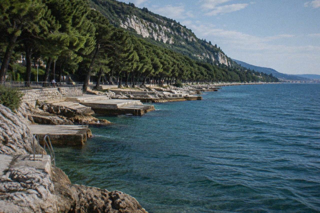 The Barcola seafront promenade in Trieste with the shoreline curve and sea on a bright day