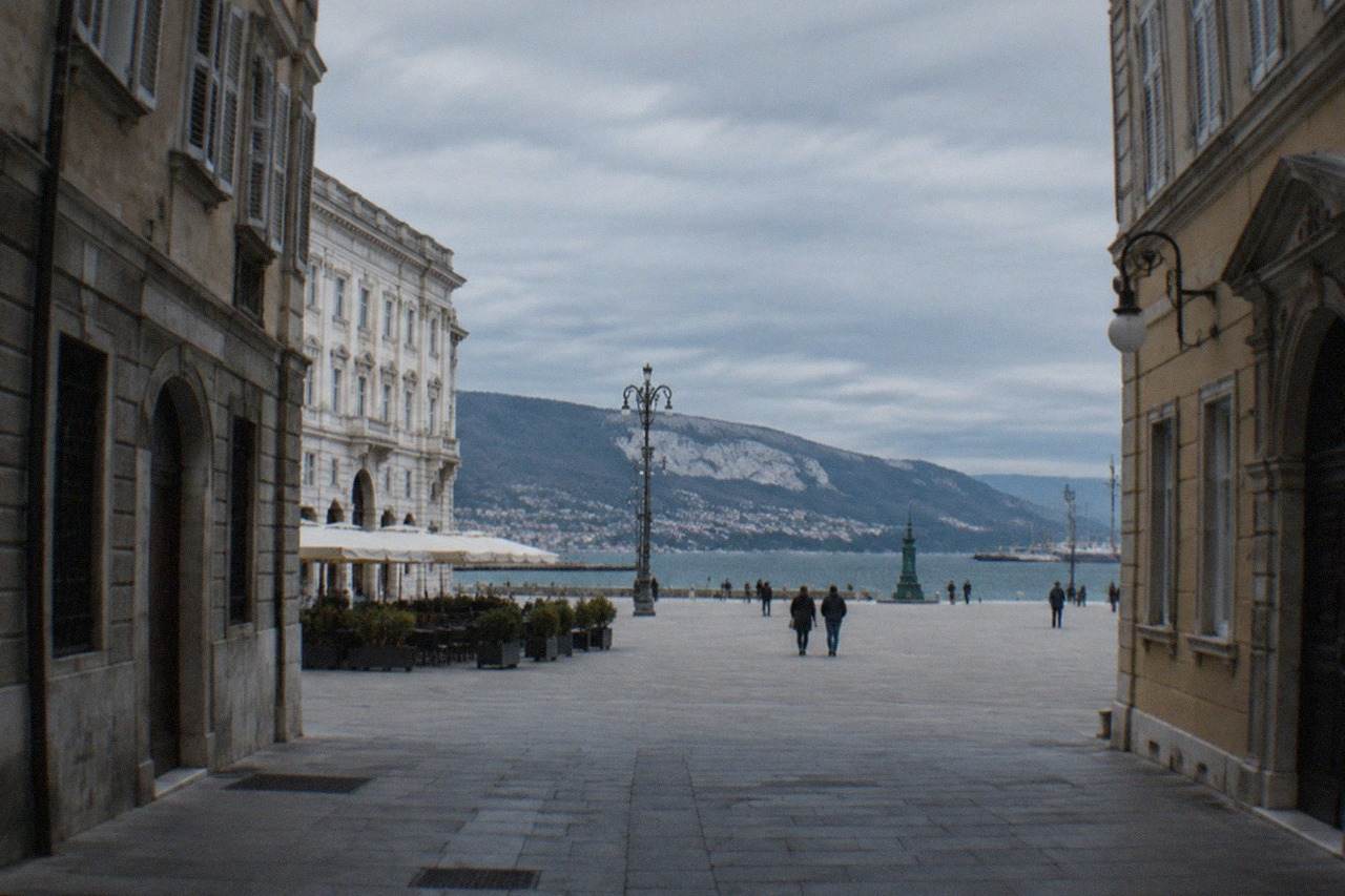 Neoclassical buildings along a wide square opening onto the sea in Trieste