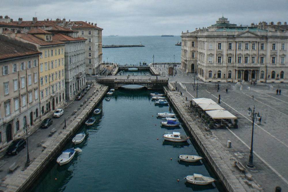 Grand square with ornate facades, open on one side to the sea