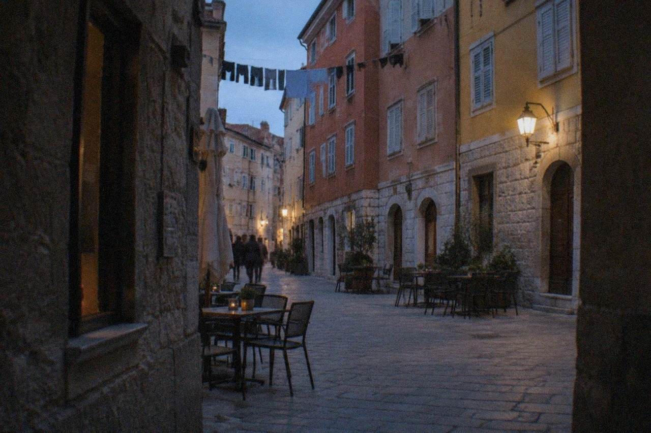 Narrow lane in the Cavana district of Trieste with old painted facades and laundry strung between the buildings