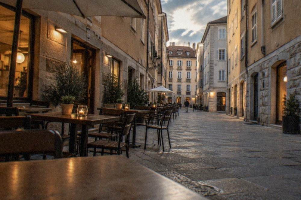 Evening view of a Cavana street in Trieste with tables outside a small restaurant and warm light in the windows