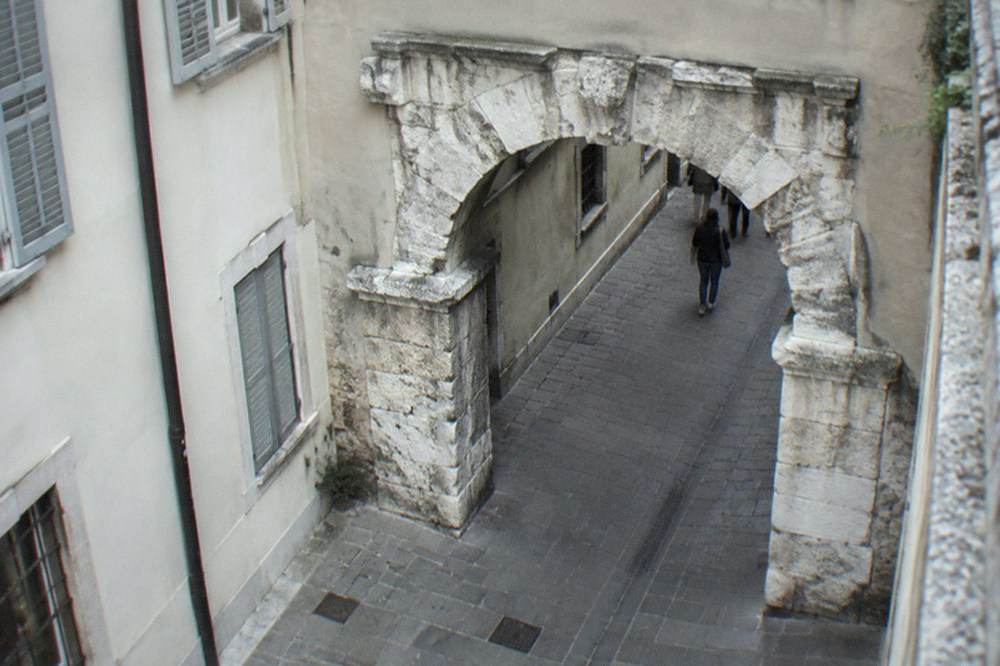 The Arco di Riccardo Roman gate standing on a street in the old town