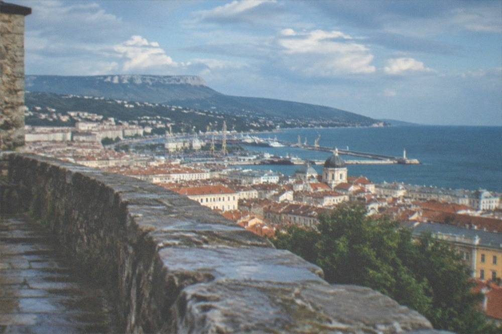 Stone wall and view over Trieste's rooftops and the Adriatic from the castle ramparts