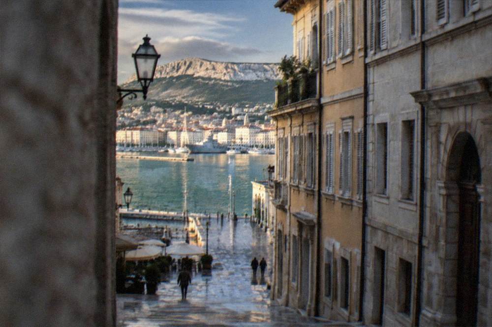 Evening view from the old town hill over the lit rooftops of Trieste and the gulf
