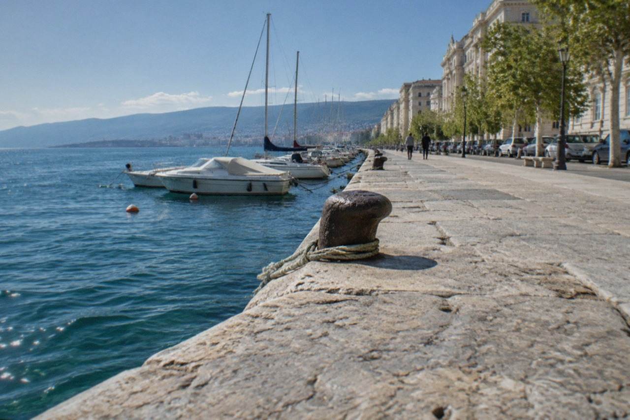 The long seafront promenade of Trieste with the gulf and distant hills in view
