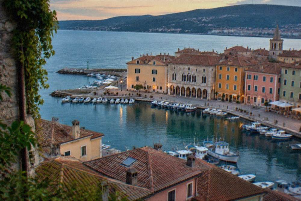 An evening view over Muggia's rooftops and harbour from the upper town