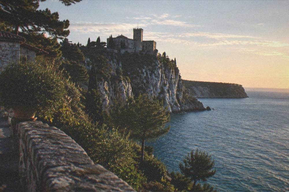 The Duino coastline at golden hour with the castle silhouette on the cliff