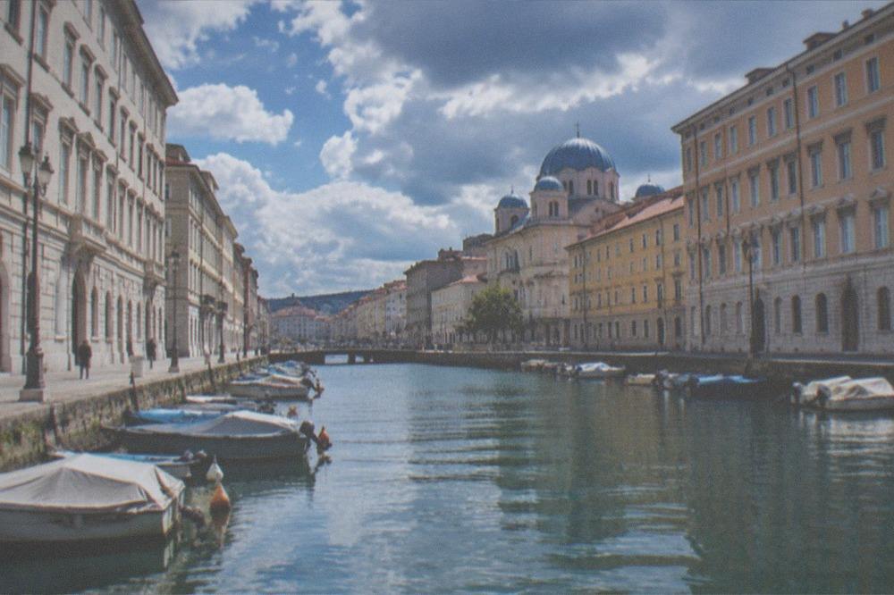 The blue domes of the Serbian Orthodox church of San Spiridione rising above rooftops near the Grand Canal in Trieste