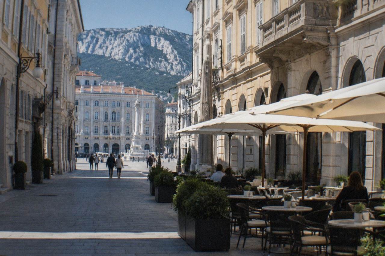An elegant Trieste street corner with grand Habsburg-era facades and a historic café terrace