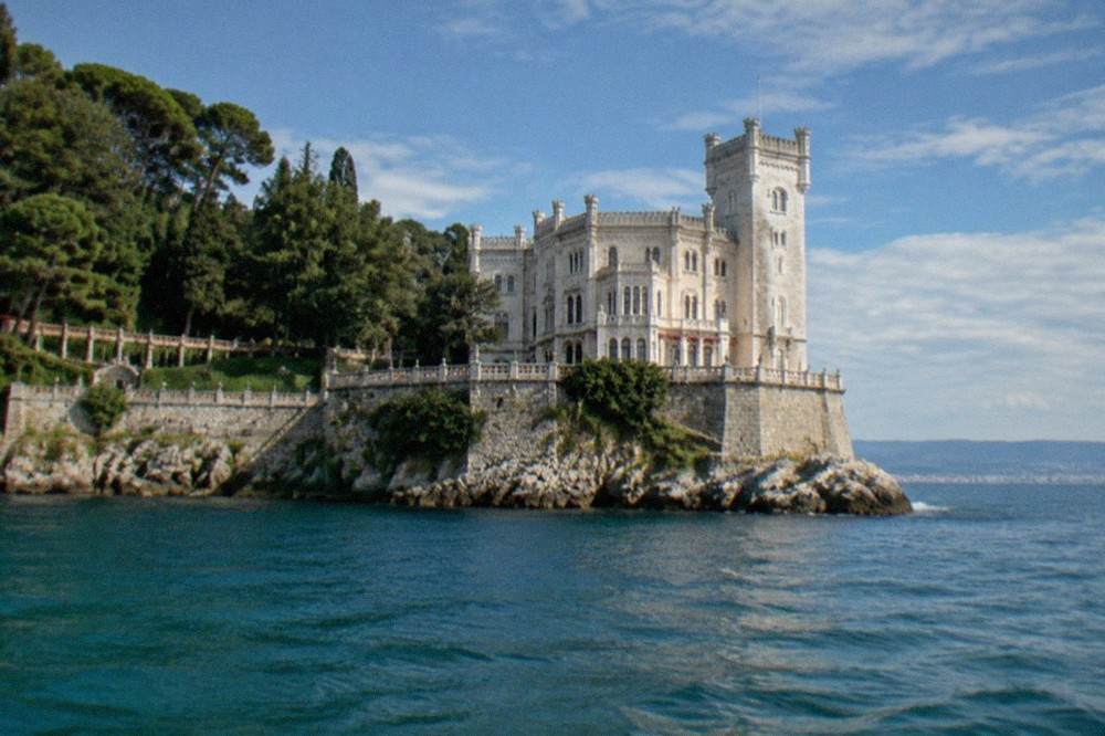 The castle seen from the water with its stone terrace and the sea beyond