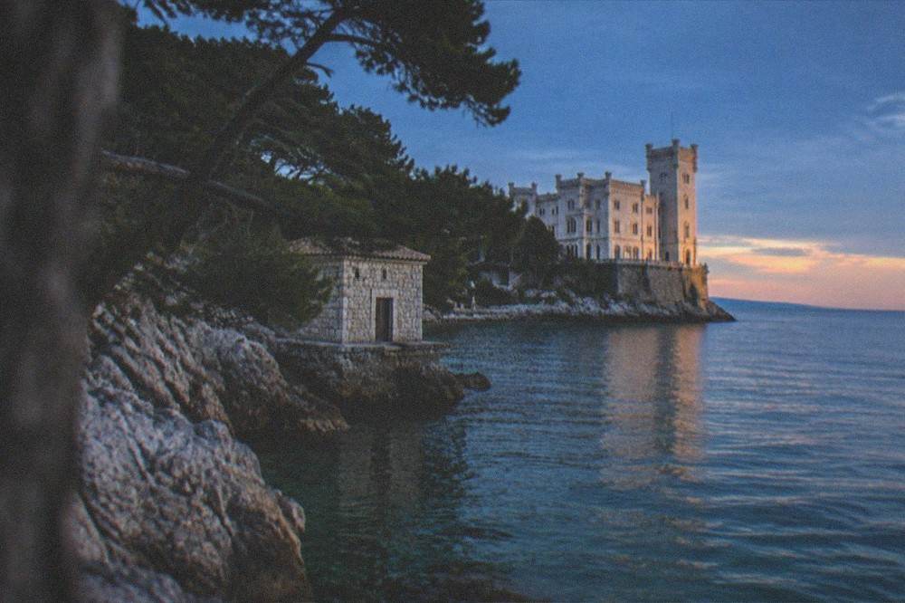 The castle seen from the water at golden hour with the sea in the foreground