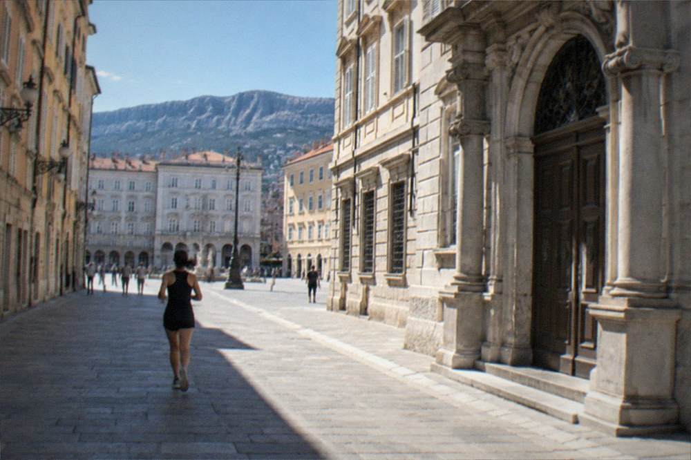 An ornate stone doorway of a historic trading building on a Trieste square