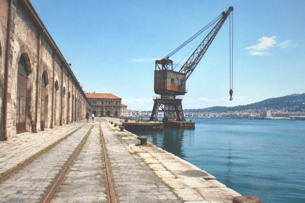 Dockside railway tracks running beside old warehouses in Trieste's port
