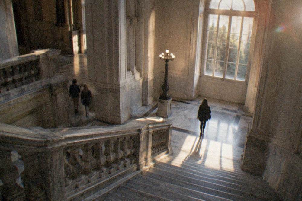 A grand interior staircase inside a 19th century Italian museum palace with marble floors
