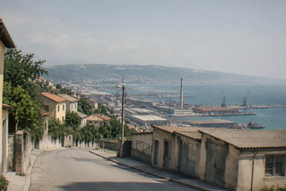 An empty street of low workshops and pale ochre houses in the Servola district of Trieste.