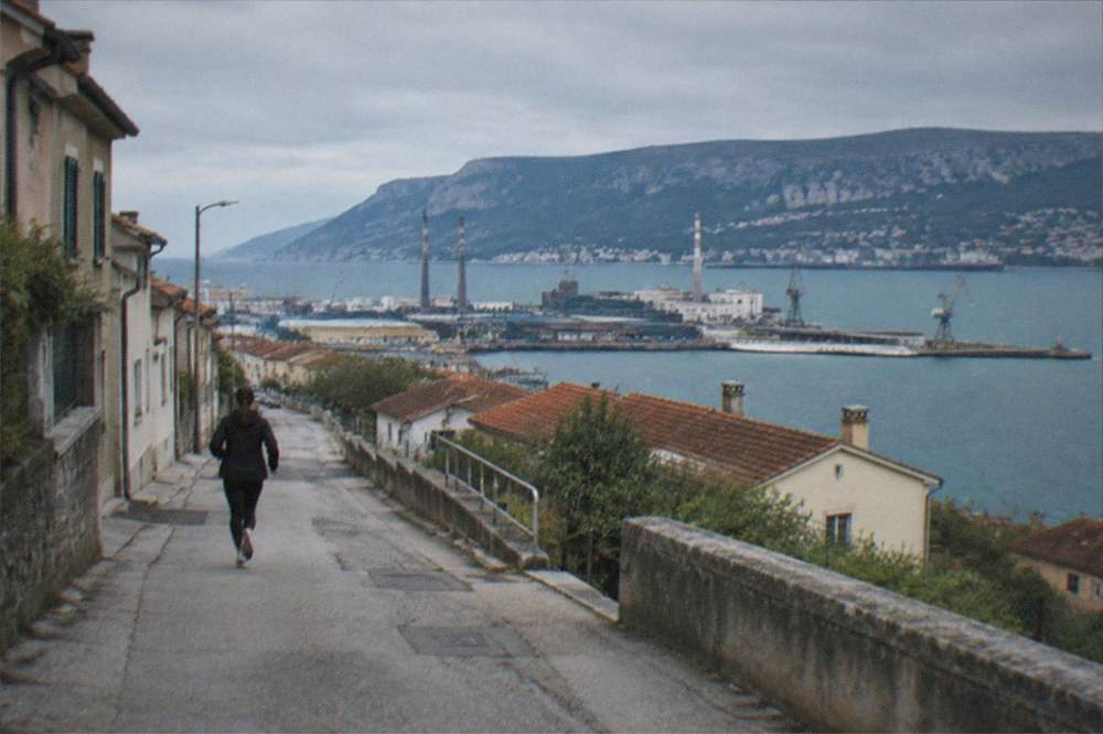 Soft morning light on a quiet street of low houses in the Servola district of Trieste.