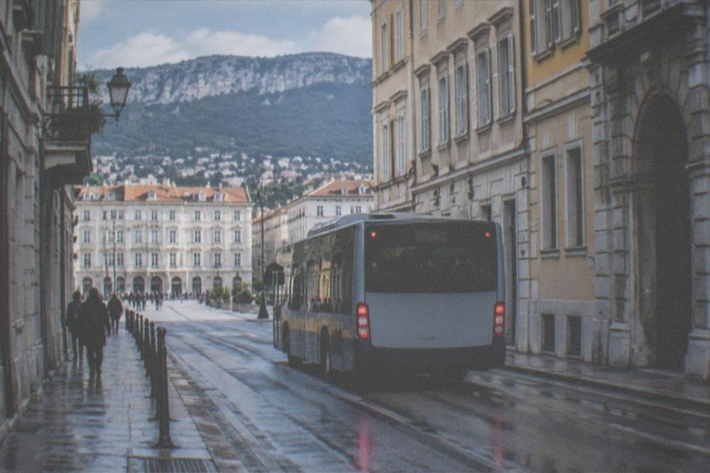 Trieste urban bus on a city street with old town buildings in the background