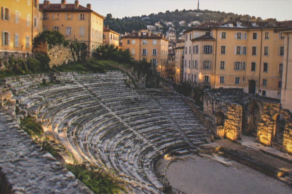 Evening view of the floodlit Roman theatre tiers in Trieste with the hill behind