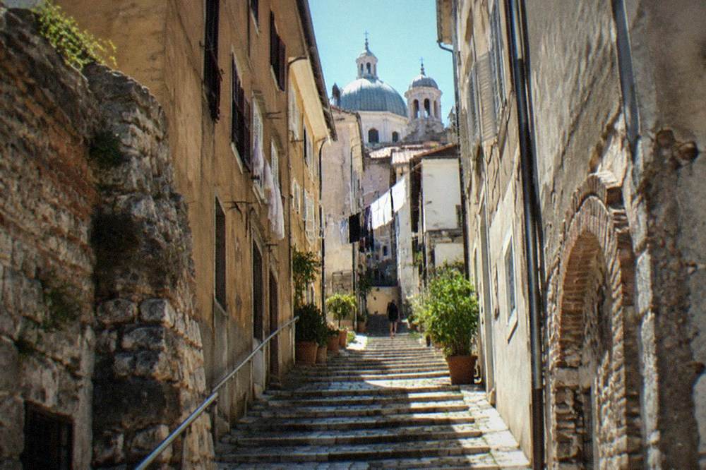 A steep narrow lane of the Città Vecchia leading up toward church domes in Trieste