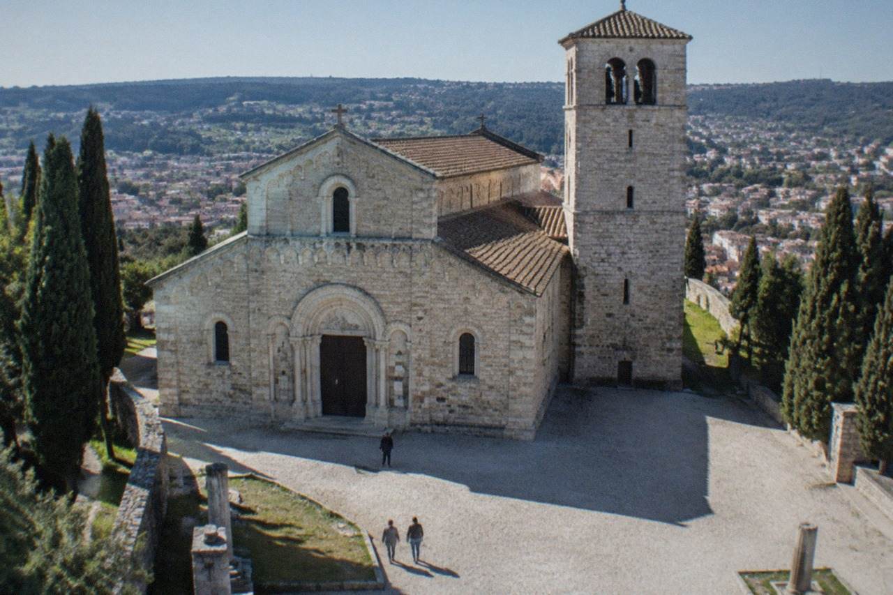 The facade and bell tower of Trieste Cathedral seen from the square on San Giusto hill