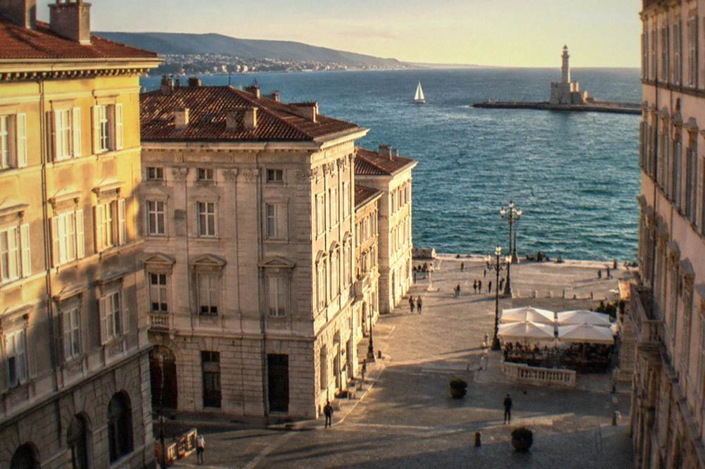 The Trieste gulf at golden hour with the lighthouse and the shoreline in view