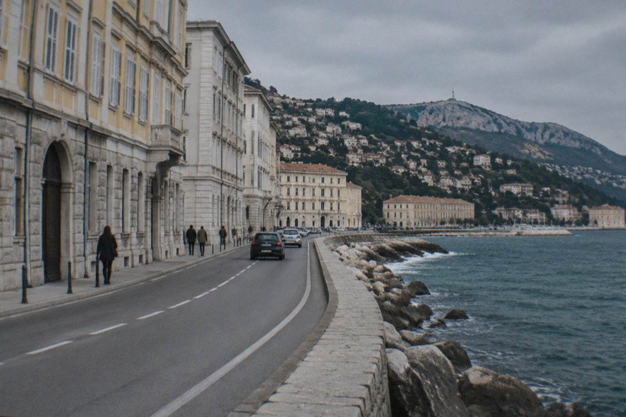 Coastal road winding along the Adriatic near Trieste with the sea on one side and green hills on the other