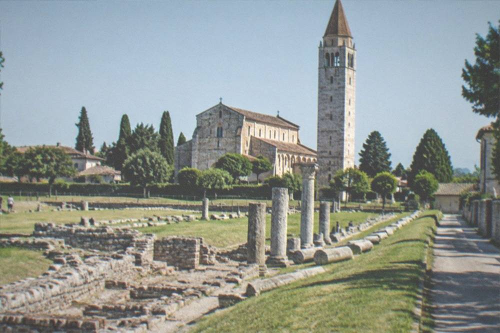 Excavated stone foundations of an ancient Roman street exposed beside a quiet village lane