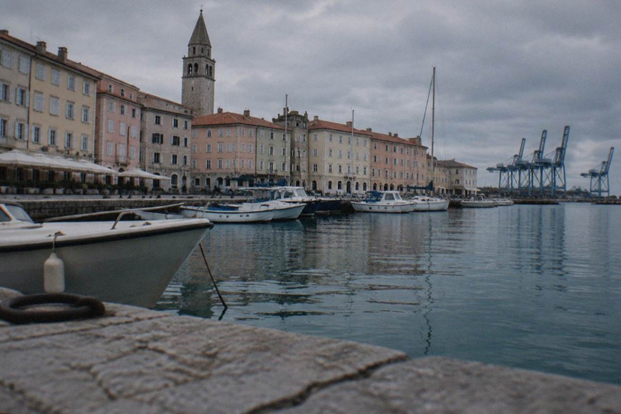 Pastel coloured facades of old buildings above a small harbour with boats