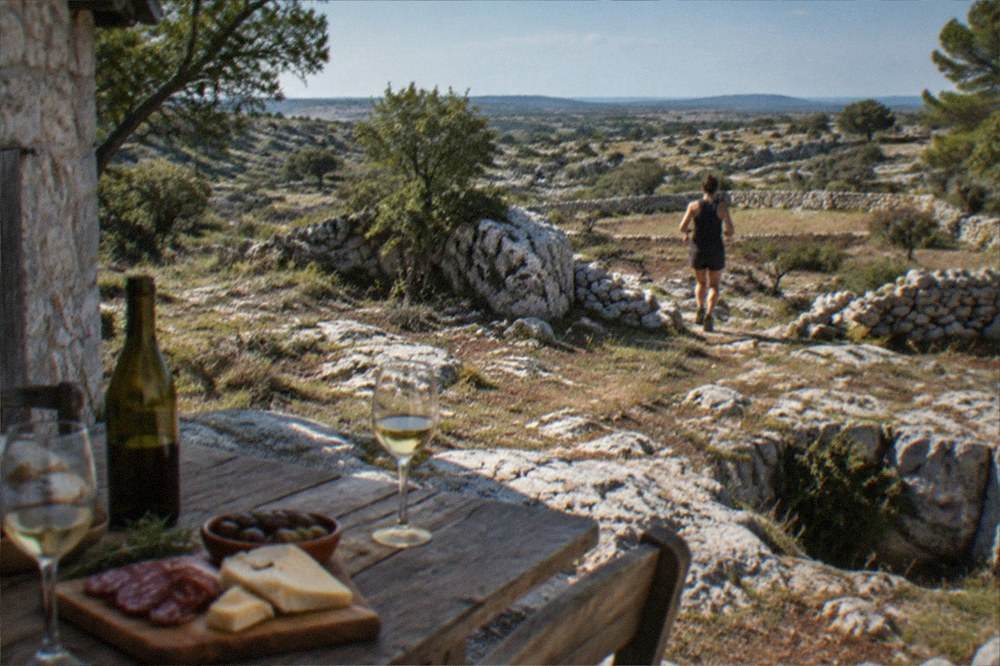 A farmhouse cellar table with glasses of local Karst wine and simple home produce