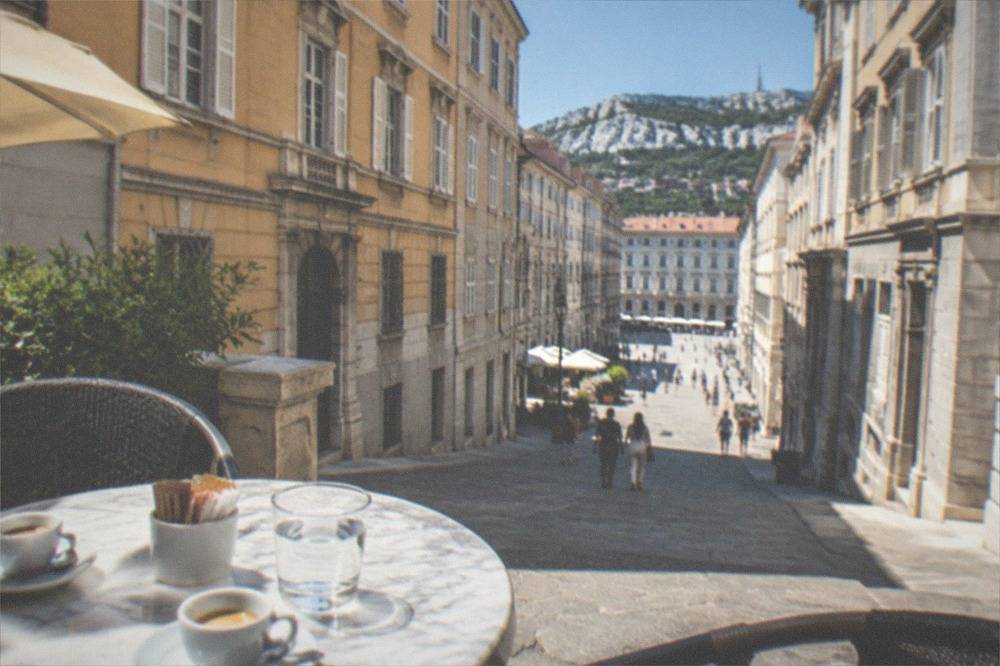 A café terrace in Trieste with small cups of espresso on a marble table