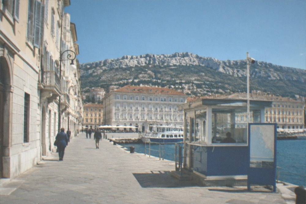 A ticket window and information board at a small harbour office on the Trieste waterfront