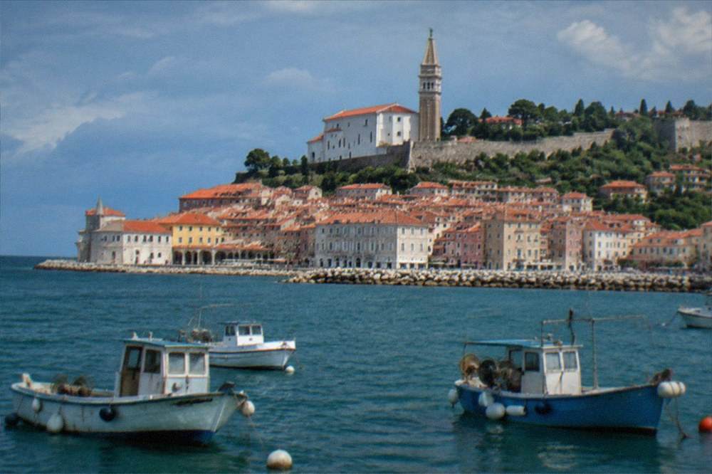 The rooftops of Piran seen from the water with fishing boats in the foreground