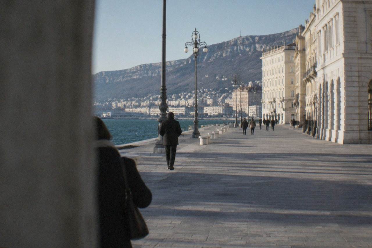 The wide seafront square of Trieste with the sea on one side and ornate facades under a clear sky