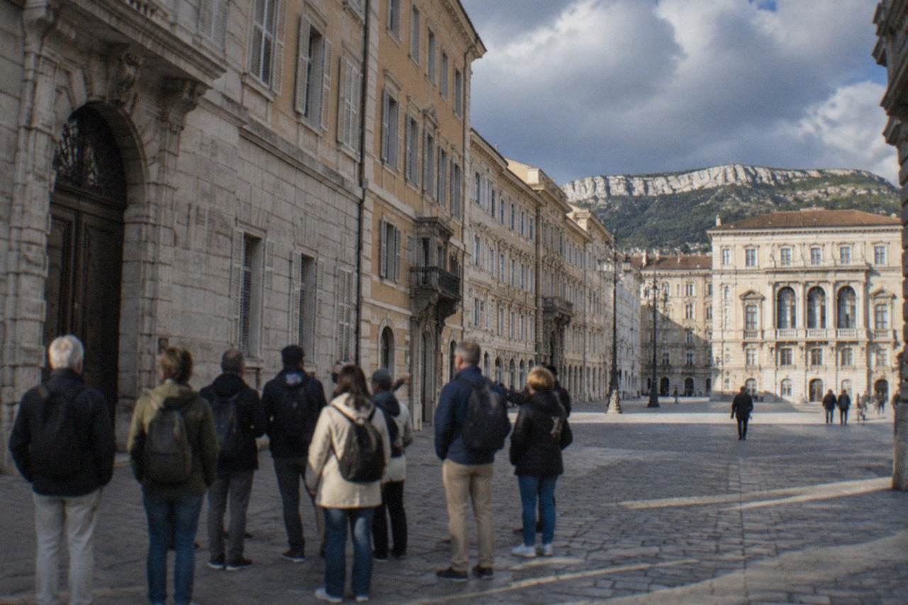 A guided group of walkers standing on a cobbled square in Trieste with ornate Habsburg-era facades behind them