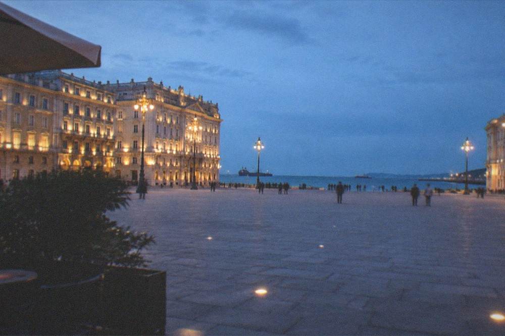 Evening light on Piazza Unità d'Italia with the illuminated facades facing the sea