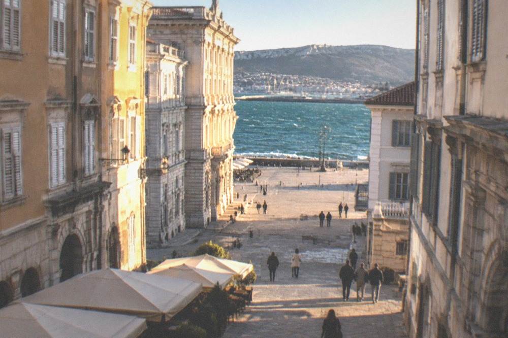 Whitecaps on the Gulf of Trieste under a clear windy sky, with the seafront in the distance