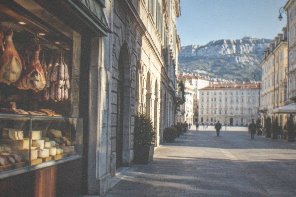 A delicatessen counter with cured hams and cheeses on display in Trieste, Italy