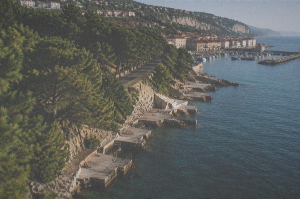 Tiled rooftops of a small coastal town on the Slovenian Adriatic above a harbour of fishing boats